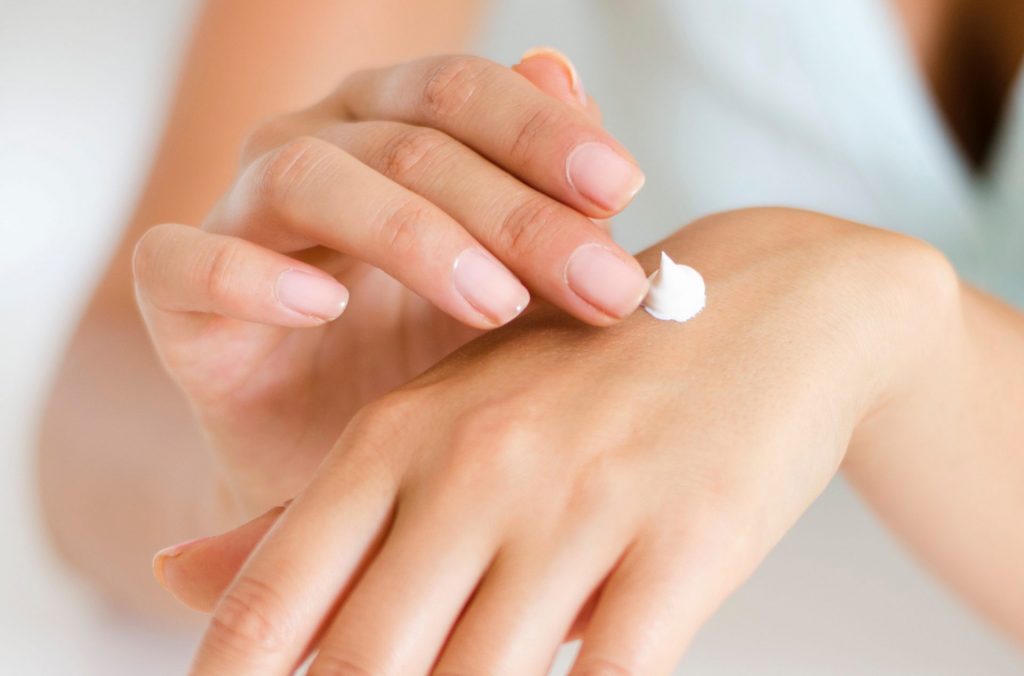 woman putting cream on hand